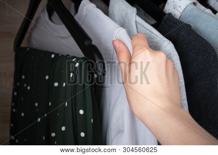 Woman Chooses Clothes For Donate From Home Wardrobe, Closeup