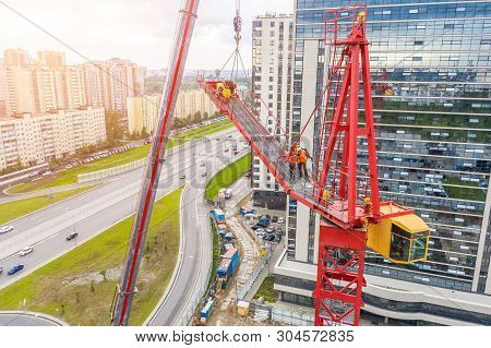 Installing The Jib Of A Construction Crane Using Another Crane On The Truck, The Work Of The Builder