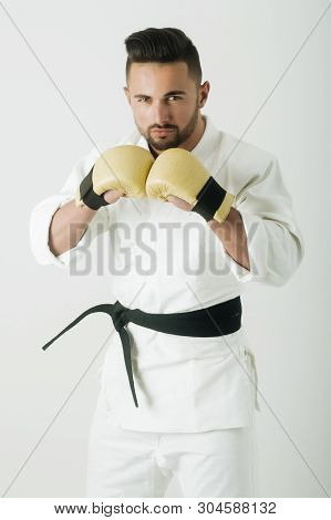 Boxer In Kimono. Man Wearing Gloves For Karate. Handsome Man Is Athlete. White Kimono With Black Bel