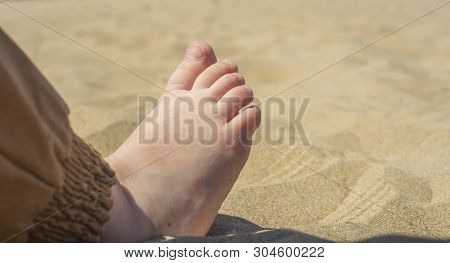 Bare Children's Feet On The Beach. Close-up