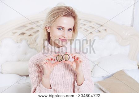 The Woman Has A Bitcoin Coin In Her Hands, With A Sweet Smile On Her Face. She Is Fond Of Cryptocurr