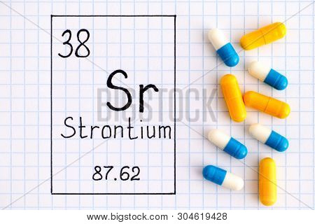 Handwriting Chemical Element Strontium Sr With Some Pills. Close-up.