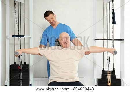 Patient Exercising Under Physiotherapist Supervision In Rehabilitation Center