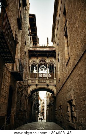 Pont del Bisbe and narrow street in Gothic Quarter in Barcelona Spain