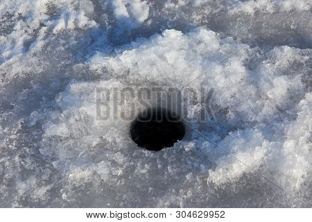 Ice-hole In Ice On A Pond, Left Fishermen