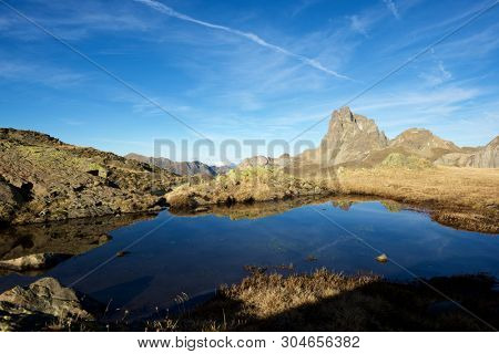 Midi Dossau Peak reflected in a lake. Ossau Valley, Pyrenees National Park, Pyrenees, France.