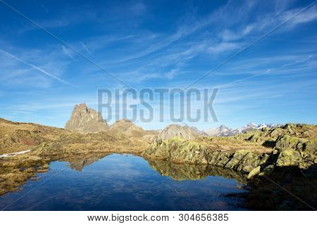 Midi Dossau Peak reflected in a lake. Ossau Valley, Pyrenees National Park, Pyrenees, France.