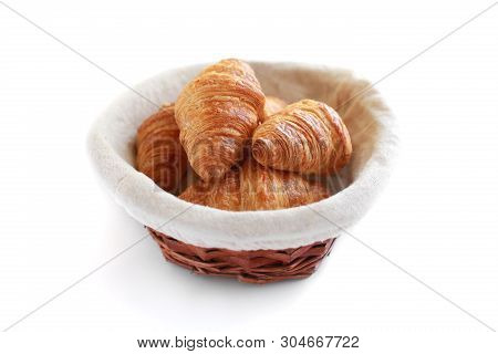Five Freshly Baked Tasty Crusty Croissants In Wicker Basket Isolated On White.