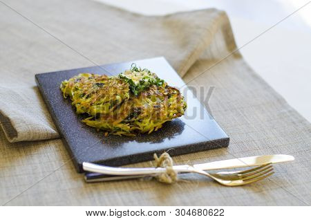 Roesti. Potatoes Grated With Greens, Fried In Butter. Serve On A Stone Board With Sour Cream, Garlic