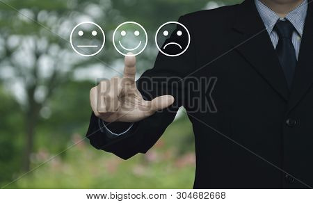Businessman Pressing Excellent Smiley Face Rating Icon Over Blur Flower And Tree In Park, Business C