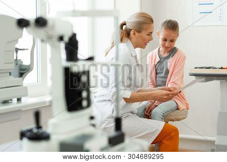 Caring Pleasant Doctor In White Robe Showing Interesting Picture