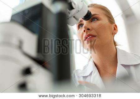 Focused Good-looking Ophthalmologist Paying Attention On Results