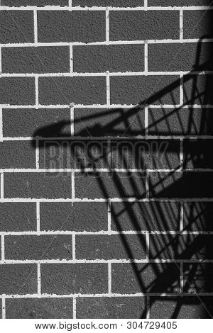 Idea Theft With The Shadow Of The Basket Trolley Black Brick Wall Background.