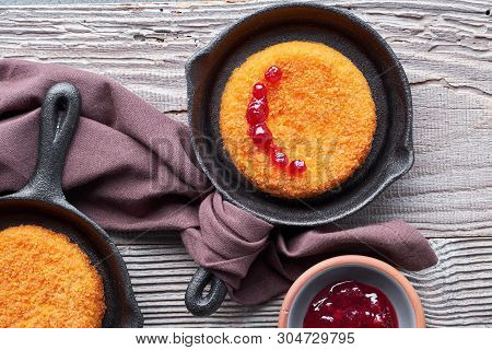 Camembert Cheese Baked In Small Iron Cast Skillets, Top View On Rustic Wooden Boards