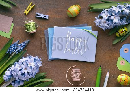 Top View Of Paper Cards, Blue Hyacinth Flowers And Easter Eggs On Dark Background. Text 