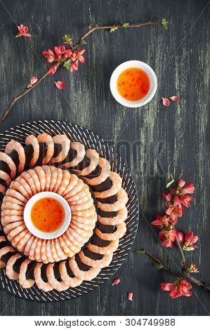 Zesty Lemon And Garlic Prawns Served On A Dark Plate With Sweet Chili Sauce, Flat Lay On Dark Backgr