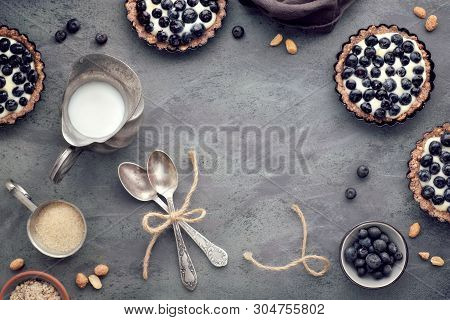 Top View On Wholegrain Blueberry Tarts With Vanilla Cream On Dark Background