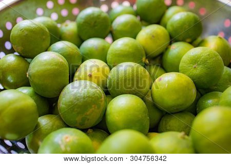 Focus And Blur On Green Lemon Lime Or Thailand Lemons On Metal Basket. Abstract Of Sweet, Sour Flavo