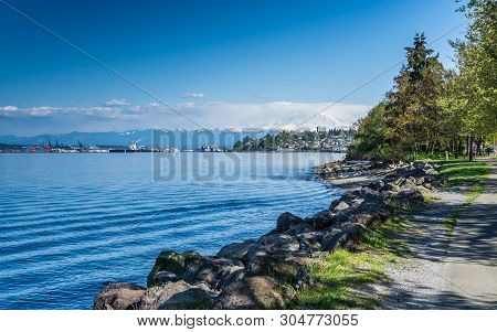 Majestic Mount Rainier Towers Over The Ruston Shoreline Near Tacoma, Washington.