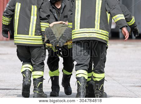 Firefighters Carrying An Injured Man On A Stretcher After A Fire