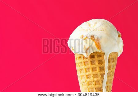 Scoop Of Delicious Melting Salted Caramel Toffee Vanilla Ice Cream In Waffle Cone On Coral Pink Back
