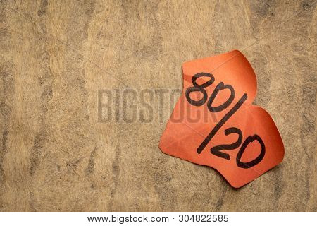 Pareto principle or eighty-twenty rule - leaf shaped sticky note against textured paper - a reminder or advice