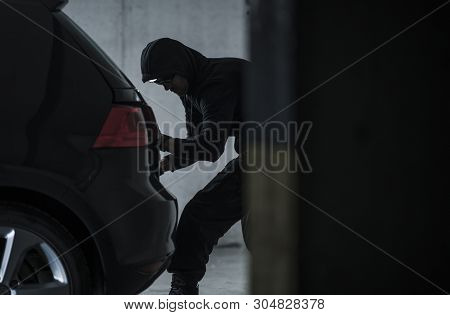 Masked Caucasian Car Thief Stealing Modern Vehicle. Transportation Theme.