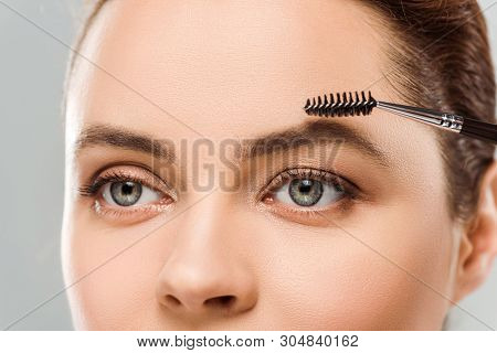 Cropped View Of Woman Shaping Eyebrow With Eyebrow Brush Isolated On Grey