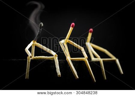 Three Characters Made Of Matchsticks Sad And Sitting In The Dark, One Away From The Other. One Of Th