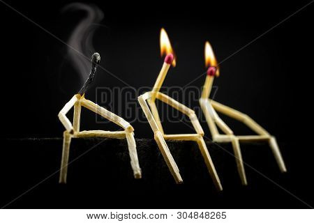 Three Characters Made Of Matchsticks Sad And Sitting In The Dark, One Away From The Other. One Of Th