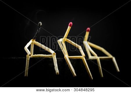 Three Characters Made Of Matchsticks Sad And Sitting In The Dark, One Away From The Other. One Of Th