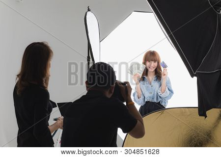 Photographer And Stylist Team Working On Studio Portrait Of Young Beautiful Asian Woman With Dark Br