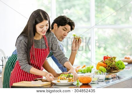 Couple In Apron Make Salad Rolls Together..