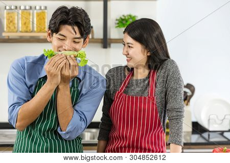 Couple In Apron Make Salad Rolls Together..