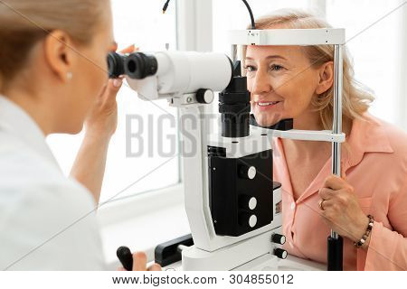 Pleasant Short-haired Woman With Blue Eyes Having Her Eyes Checked
