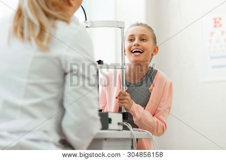 Cheerful Excited Kid With Wide Smile Talking With Pleasant Doctor