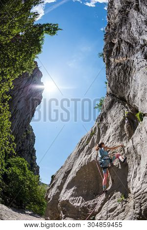 Rock Climbing And Mountaineering In The Paklenica National Park. A Woman Overcomes A Challenging Cli