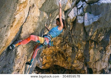 Rock Climbing And Mountaineering In The Paklenica National Park. A Woman Overcomes A Challenging Cli