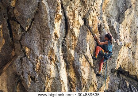 Rock Climbing And Mountaineering In The Paklenica National Park. A Woman Overcomes A Challenging Cli