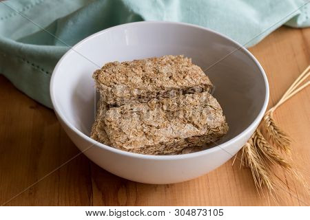 Wheat Cereal In Bowl With Wheat Spears On Wooden Table