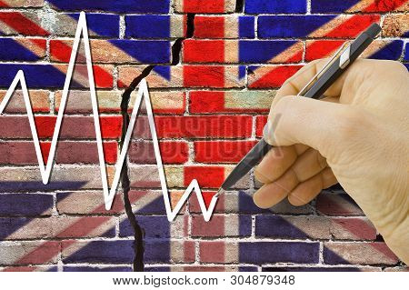Hand Drawing A Graph About The Performance Of The English Economy
Against A Cracked Brick Wall With 