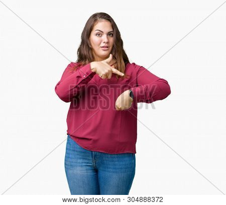 Beautiful plus size young woman over isolated background In hurry pointing to watch time, impatience, upset and angry for deadline delay