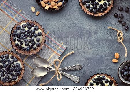 Top View On Wholegrain Blueberry Tarts With Vanilla Cream On Dark Background