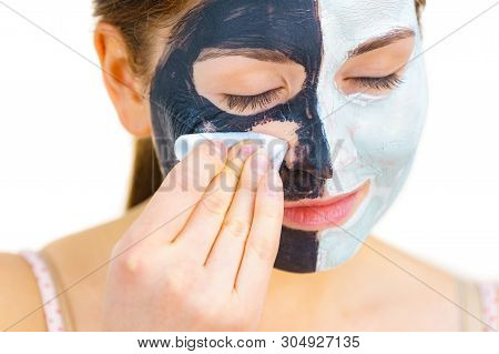 Woman With Clay Carbo Black Mask On One Half Face And White Mud On Second Half. Girl Removing Cosmet