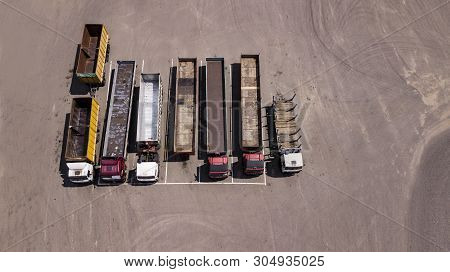 Trucks Stand In A Row Parking Lot - Top View From The Drone