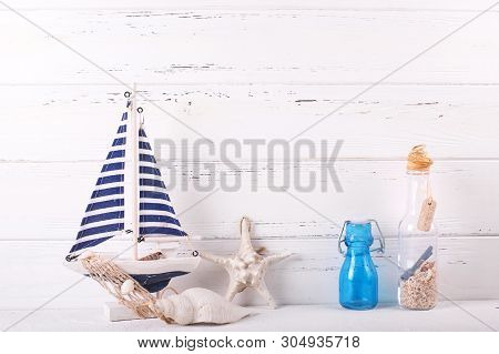 Nautical Decorations Near By  Wooden Brick Wall. Decorative Boat Or Ship, Star Fish, Shell, Blue Bot