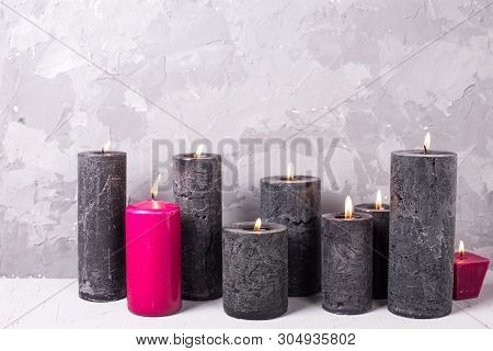 Black And Red  Burning Candles  On Grey Textured Background. Spa Or Still Life Concept. Selective Fo