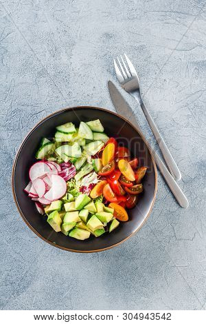 Vegan Buddha Bowl. Bowl With Fresh Raw Vegetables - Cherry Tomatoes, Cucumber, Radish, Avocado, Lett