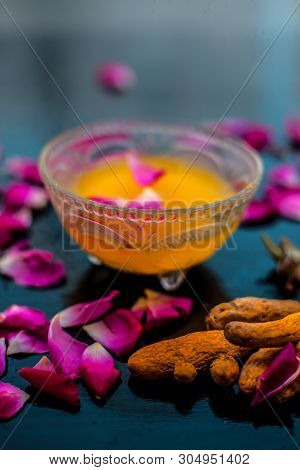 Milk Face Pack On Black Shiny Surface Consisting Of Raw Milk,turmeric Or Haldi And Badam In A Glass