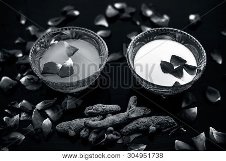 Milk Face Pack On Black Shiny Surface Consisting Of Raw Milk,turmeric Or Haldi And Badam In A Glass